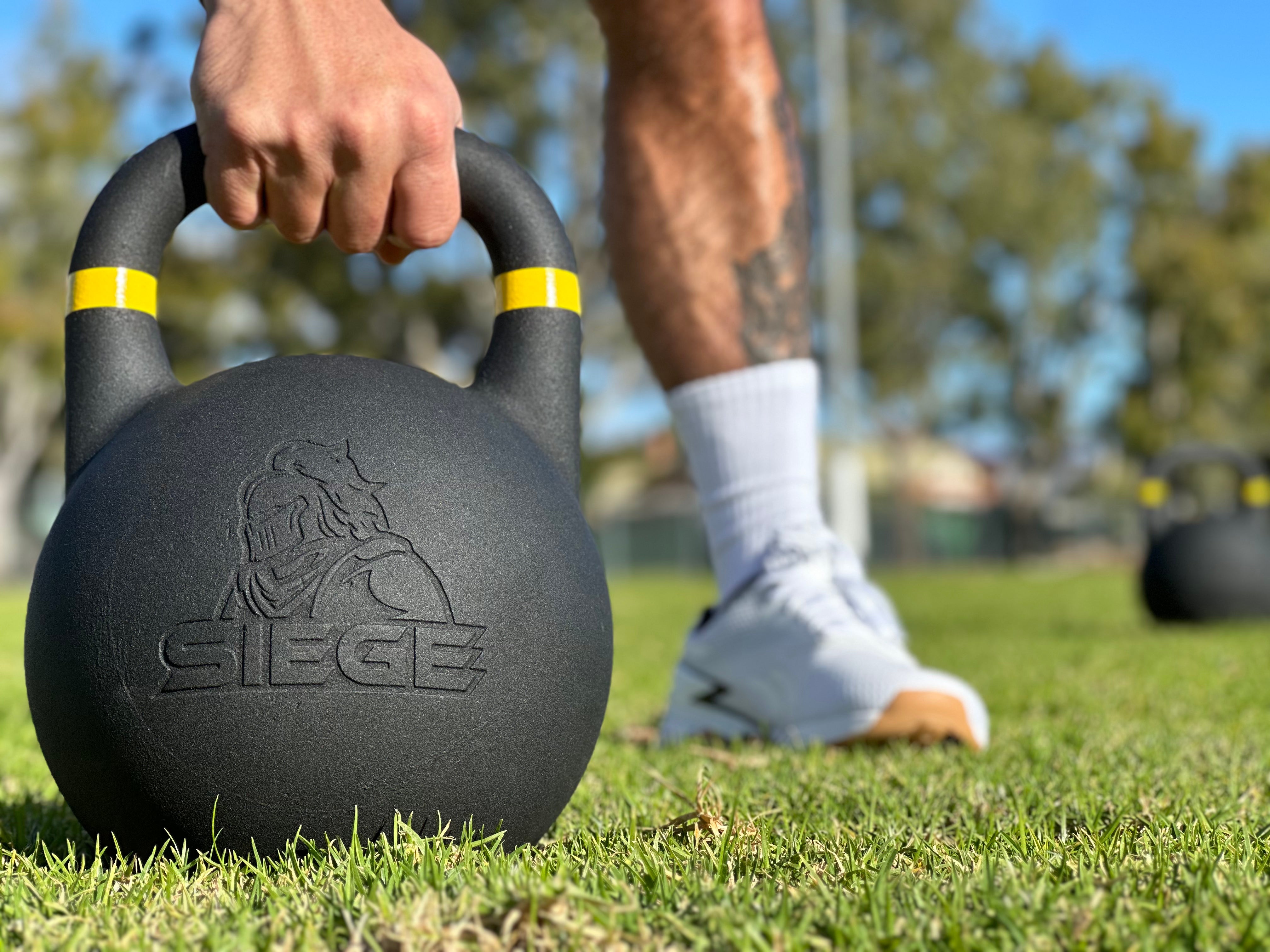 SIEGE matte black powder coat cast iron competition kettlebell outdoor training on green grass